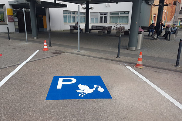 Áreas de estacionamiento en azul para mujeres embarazadas con el símbolo de la cigüeña